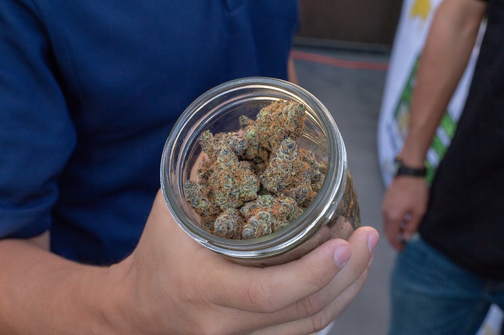 person holding jar of MMJ product